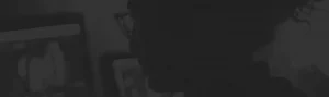 In the dimly lit room, a silhouette of a person wearing glasses intently reads a letter from Symphonic's CEO on their computer screen.